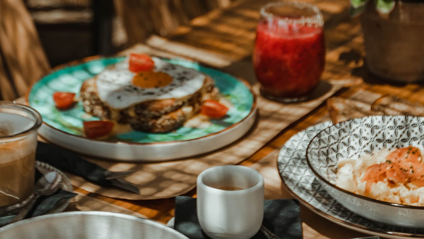 Eggs in koulouri with cherry tomatoes on a turquoise plate, up close