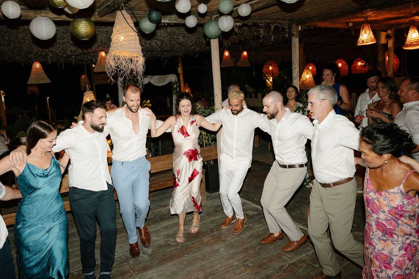 Guests dancing hand in hand in a circle on the deck