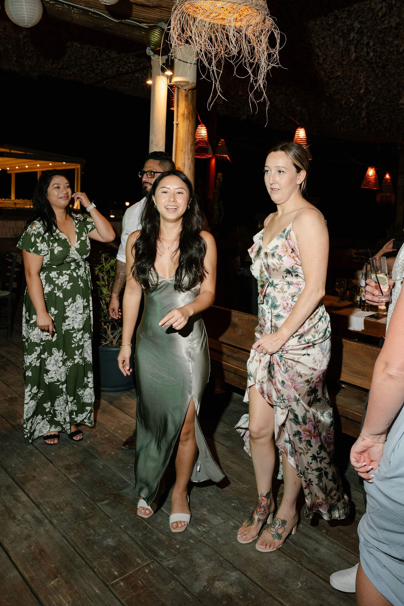 Guests gathered on the deck under glowing lanterns at night