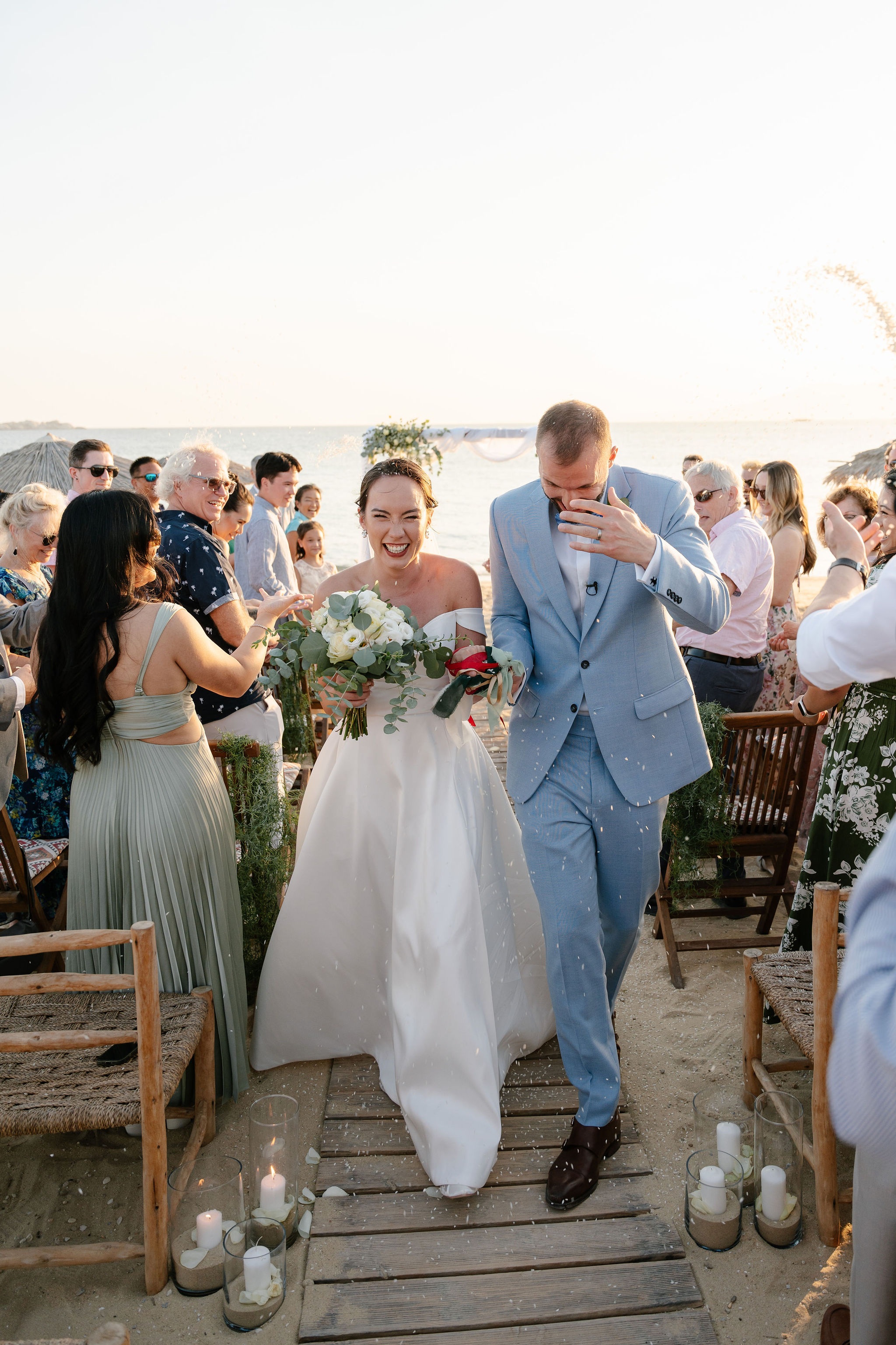 Newlyweds walking back up the aisle through a shower of confetti