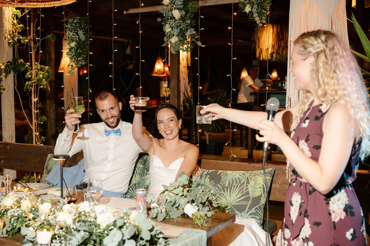 The couple raising a toast at their candlelit table