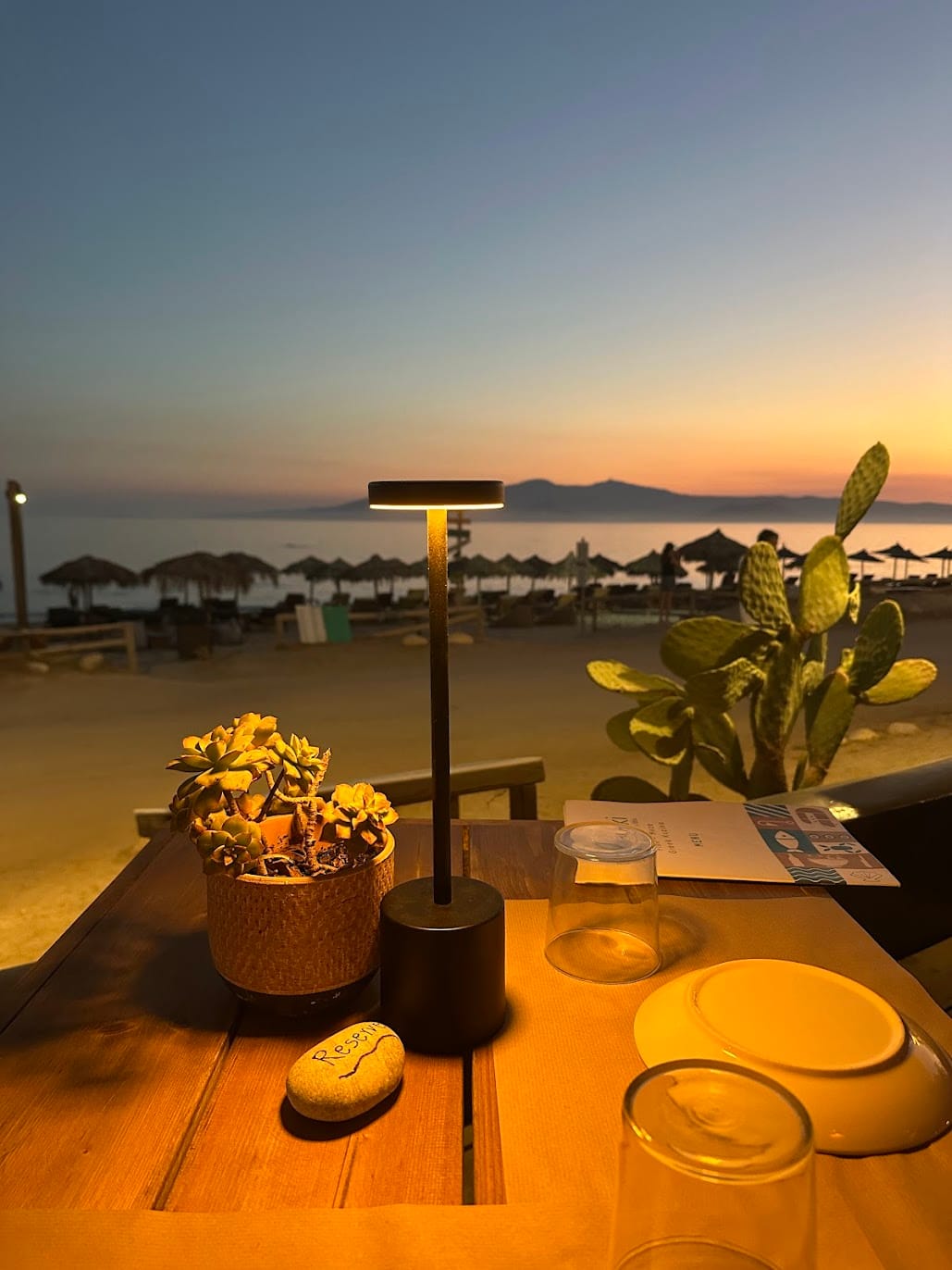 A table set at dusk with the sea behind