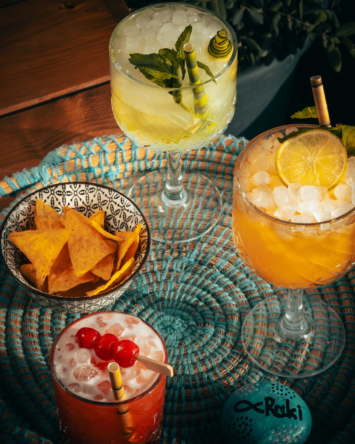 A trio of signature cocktails on a woven tray