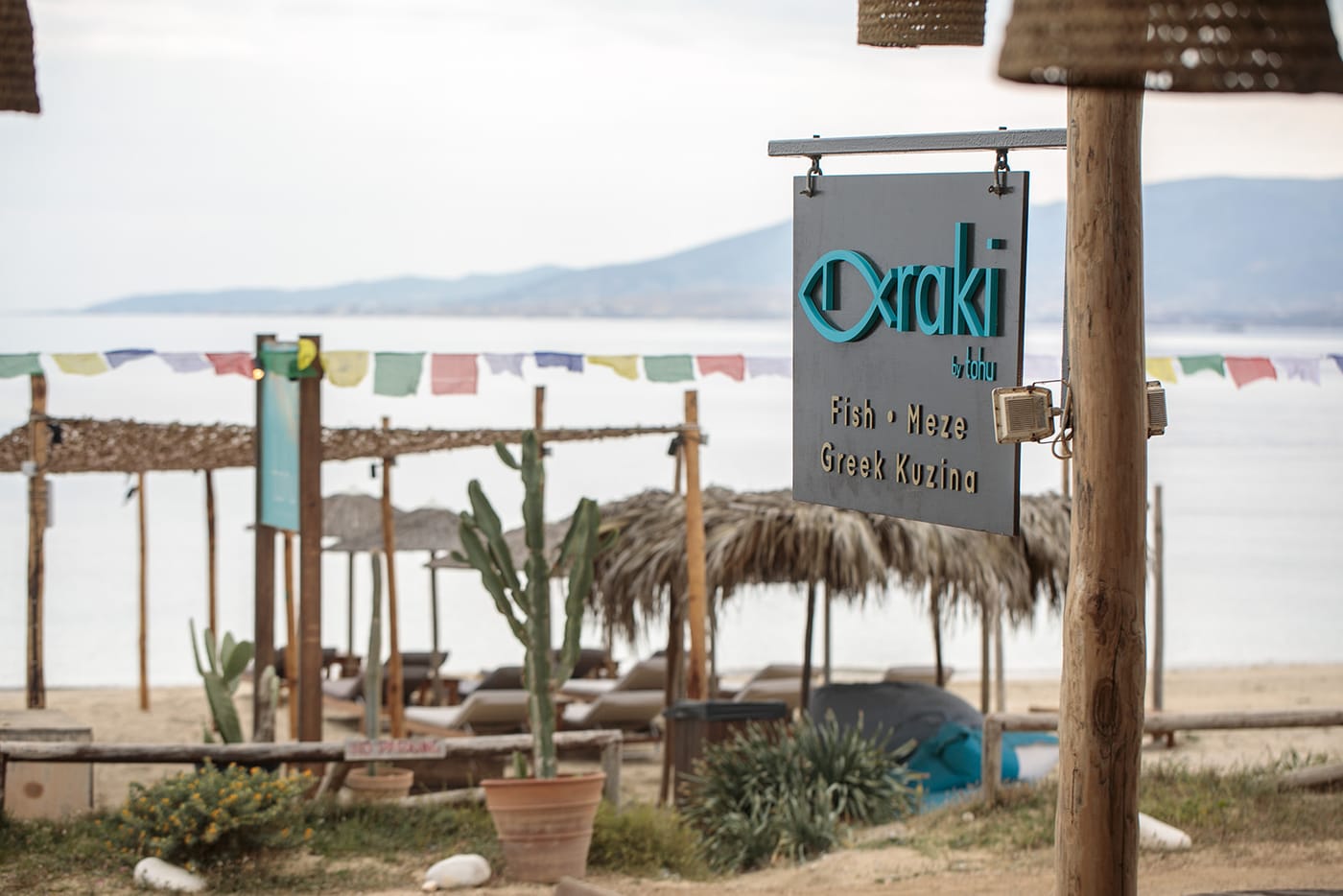 The Psaraki by Tohu sign above the beach with prayer flags
