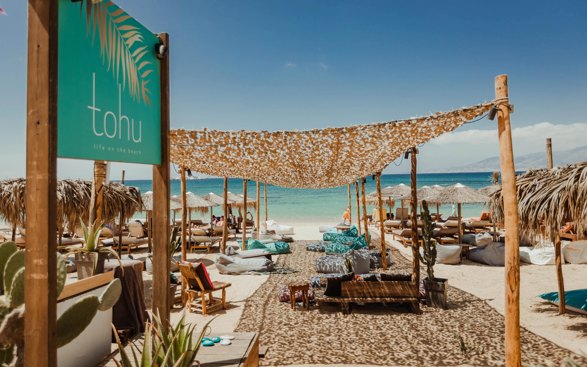 The tohu beach setup under the reed canopy facing the turquoise sea
