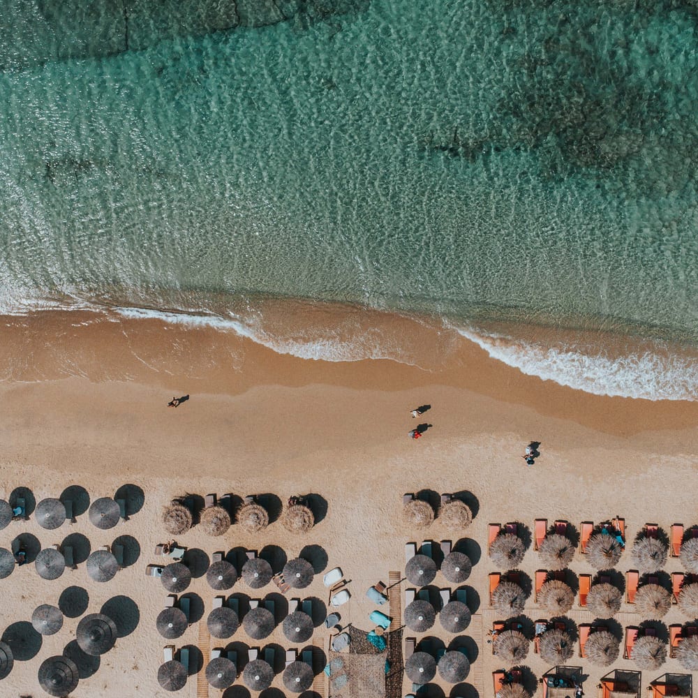 Aerial view of the beach umbrellas and turquoise surf