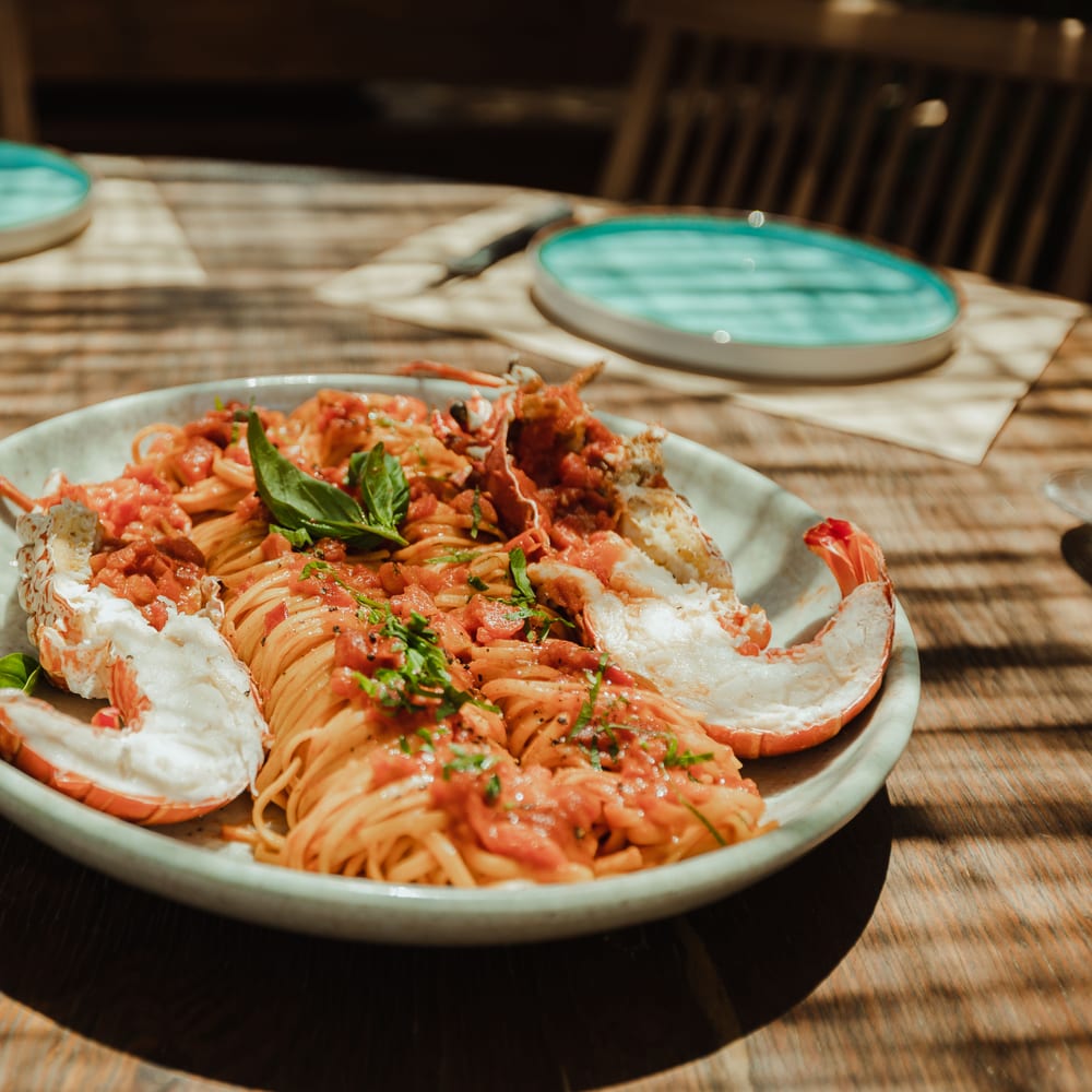 Lobster linguine on a turquoise-rimmed plate