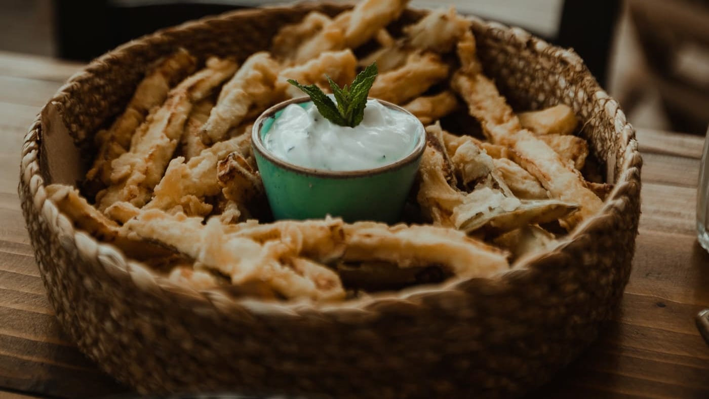 A basket of fresh bread with a homemade dip