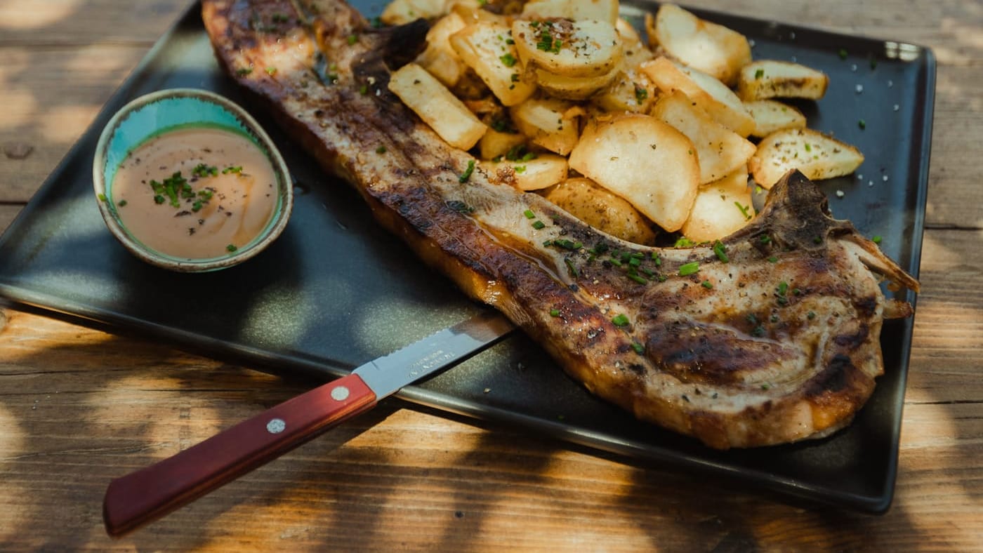 A grilled pork chop with Naxian potatoes