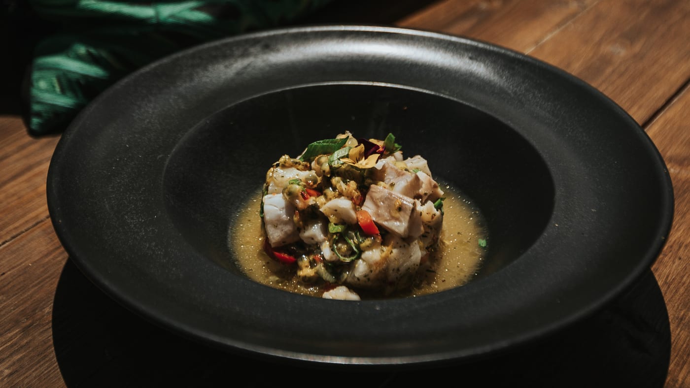 Sea bass ceviche in a black bowl, up close