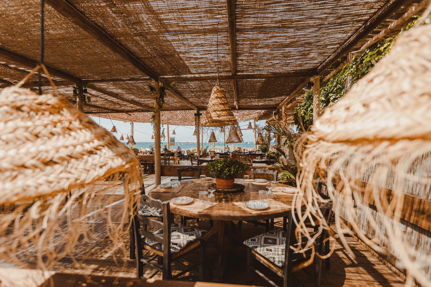 Tables under the reed canopy looking out to the sea